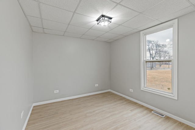empty room featuring light wood finished floors, baseboards, and visible vents