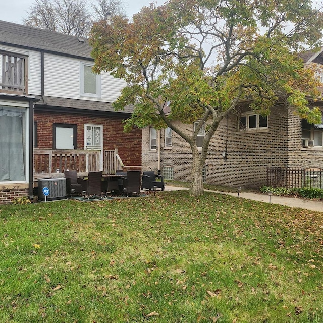 8034 S Clyde Ave, Chicago, IL 60617 - back of property with cooling unit, brick siding, roof with shingles, and a lawn