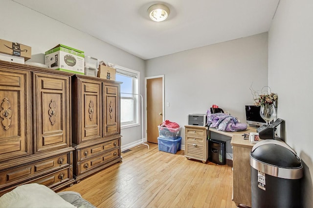 home office featuring baseboards and light wood finished floors