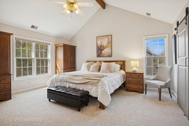bedroom featuring light colored carpet, beamed ceiling, visible vents, and a barn door