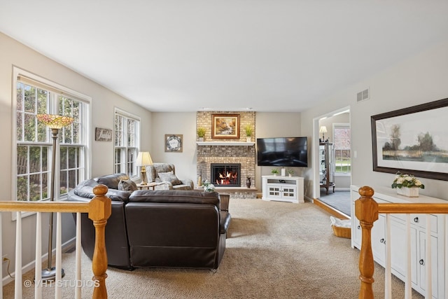 living room with visible vents, a wealth of natural light, carpet, and a fireplace