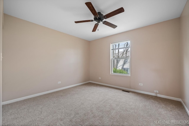 carpeted empty room with visible vents, ceiling fan, and baseboards