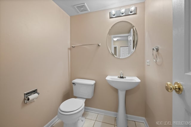 bathroom featuring a sink, toilet, visible vents, baseboards, and tile patterned flooring