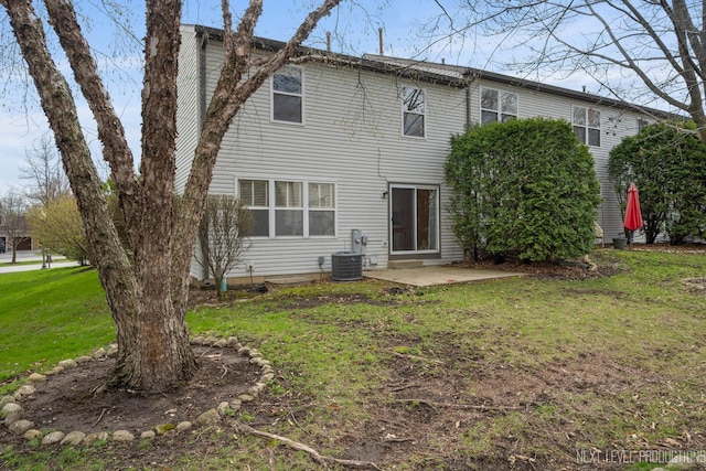 back of property with a lawn, central air condition unit, and a patio