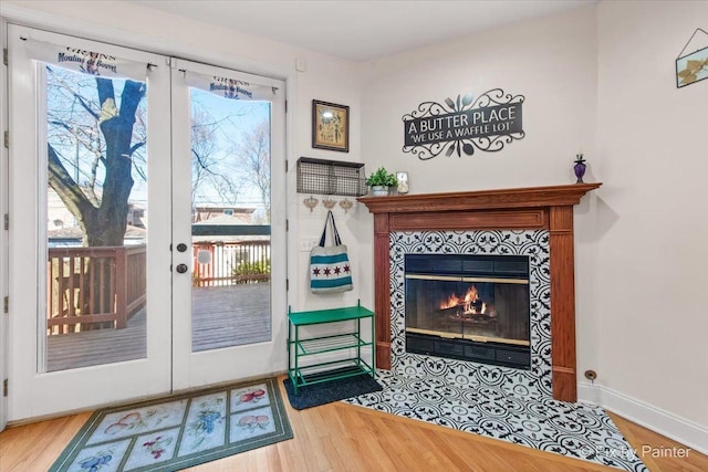 623 Oakton St, Evanston, IL 60202 - doorway with baseboards, wood finished floors, a tile fireplace, and french doors