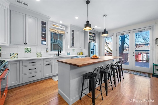 623 Oakton St, Evanston, IL 60202 - kitchen featuring butcher block countertops, visible vents, appliances with stainless steel finishes, a sink, and a kitchen breakfast bar