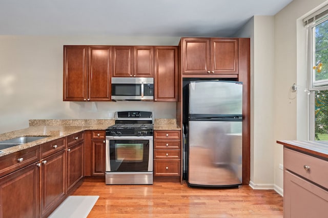 507 Grove Ln Unit H, Forest Park, IL 60130 - kitchen with a sink, light wood-style flooring, appliances with stainless steel finishes, and light stone countertops