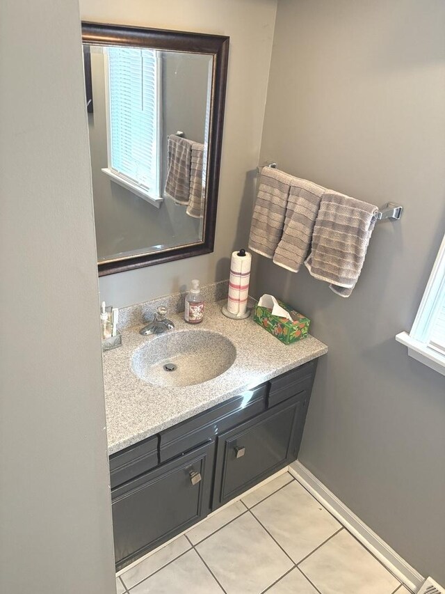 bathroom with tile patterned flooring, vanity, and baseboards