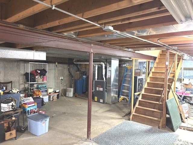unfinished basement with heating unit and stairway
