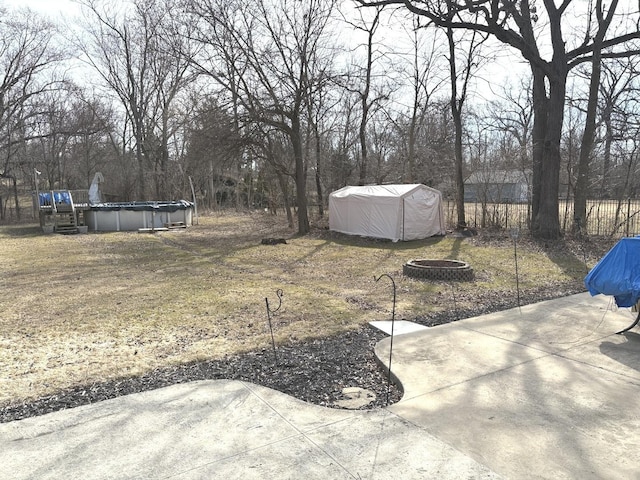 view of yard featuring a patio, a fire pit, and an outdoor pool
