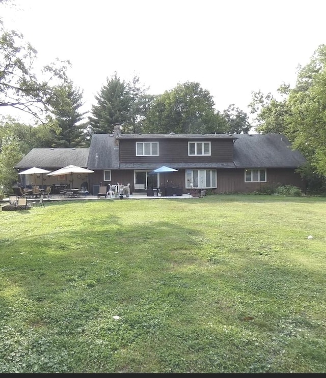back of property with a gazebo, a patio area, and a lawn