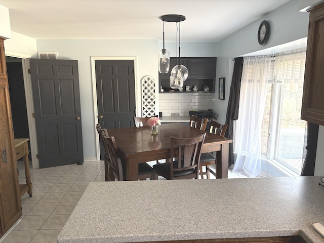 dining area with light tile patterned flooring, vaulted ceiling, and visible vents