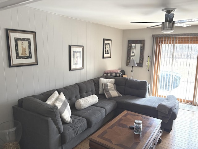 living area featuring a wealth of natural light, ceiling fan, and wood-type flooring