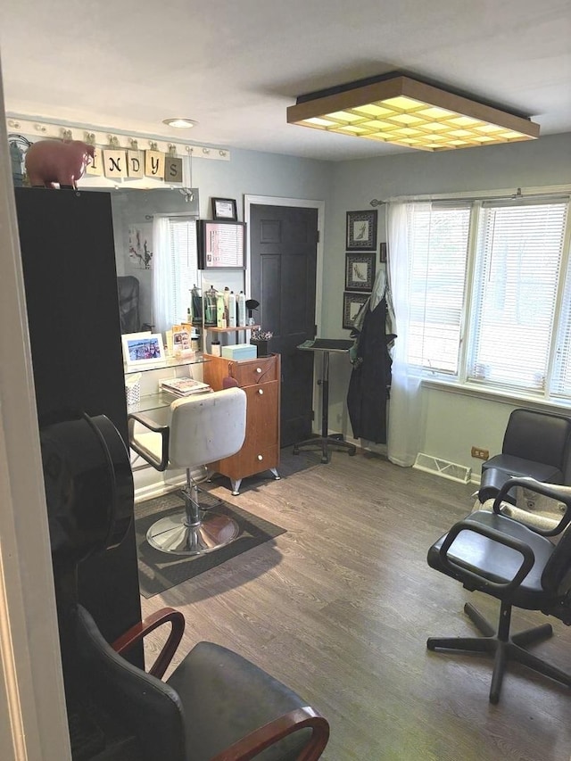 office area with baseboards, visible vents, and wood finished floors