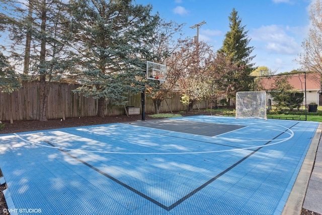 view of basketball court featuring basketball court and fence