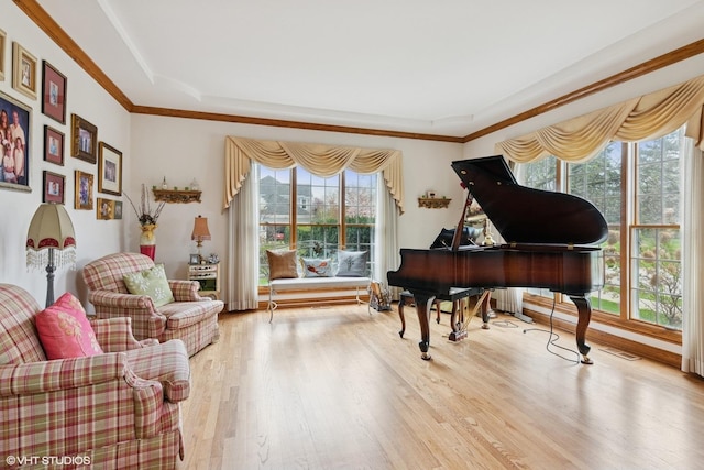 sitting room with wood finished floors, crown molding, and visible vents