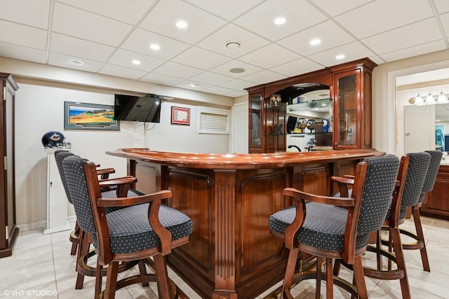 bar featuring light tile patterned flooring, recessed lighting, indoor wet bar, and a paneled ceiling