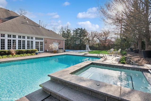 view of swimming pool featuring a fenced in pool, an in ground hot tub, and a patio area