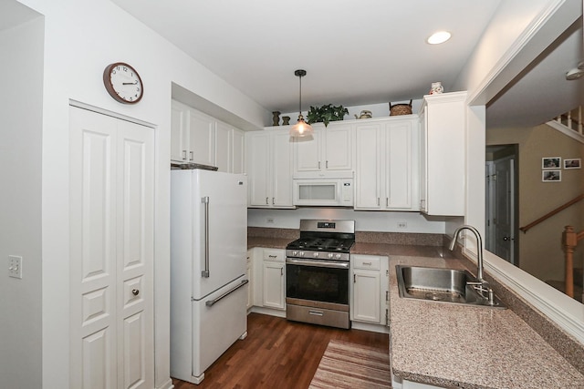 kitchen with dark wood-style flooring, white appliances, white cabinetry, a sink, and pendant lighting