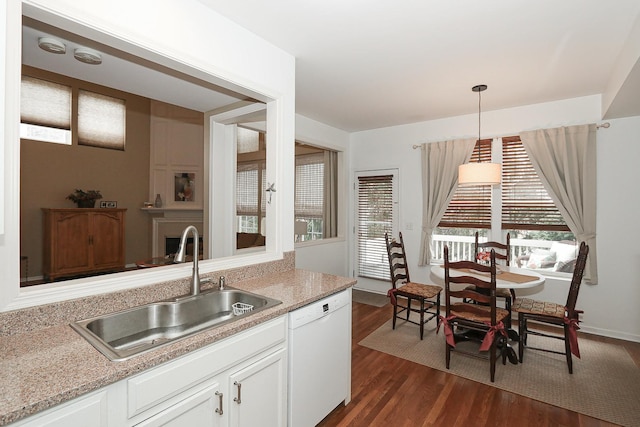 kitchen with a sink, white dishwasher, a wealth of natural light, and dark wood finished floors