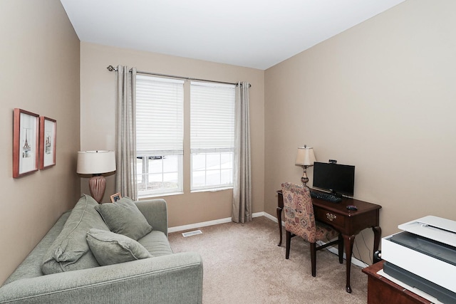 office area featuring light carpet and baseboards