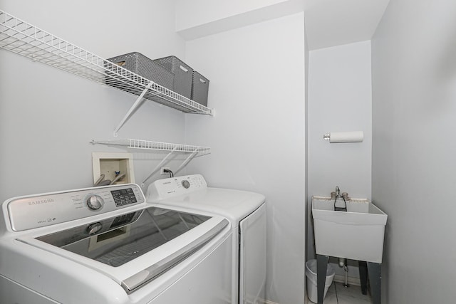 washroom with independent washer and dryer, a sink, and laundry area