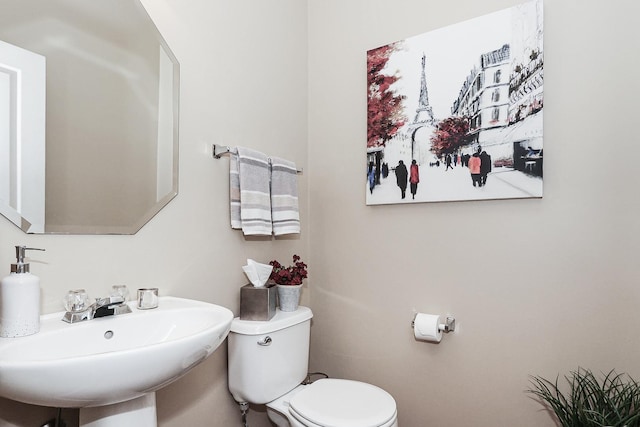 half bathroom with toilet and a sink