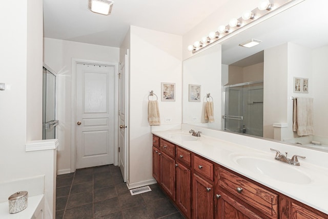 bathroom with double vanity, a sink, visible vents, and a shower stall