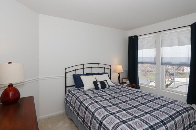 bedroom featuring baseboards and light colored carpet