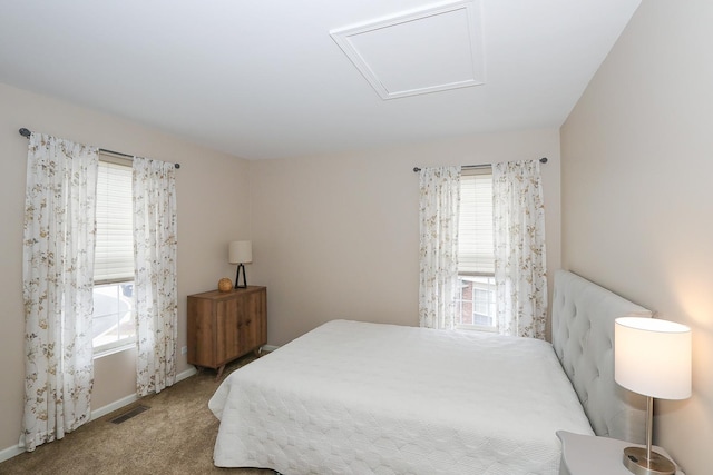 bedroom with baseboards, carpet floors, visible vents, and attic access