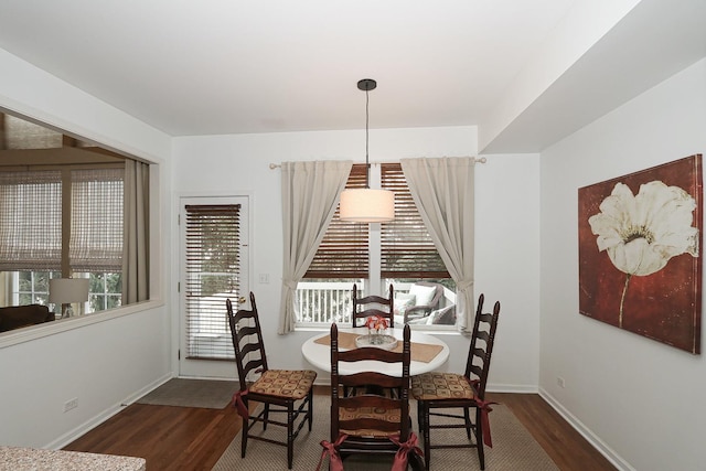 dining area with baseboards, a wealth of natural light, and wood finished floors