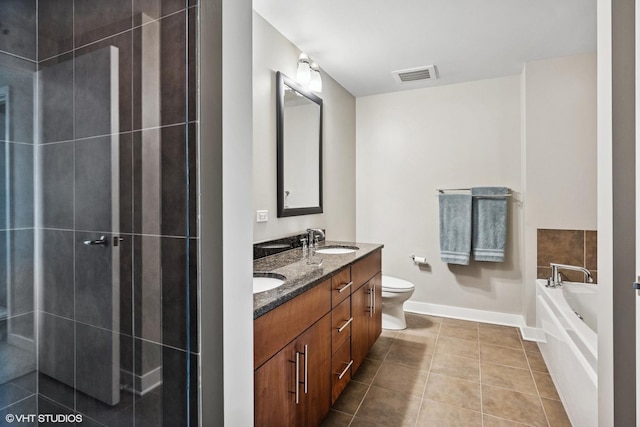 bathroom featuring baseboards, double vanity, a bath, tile patterned flooring, and toilet
