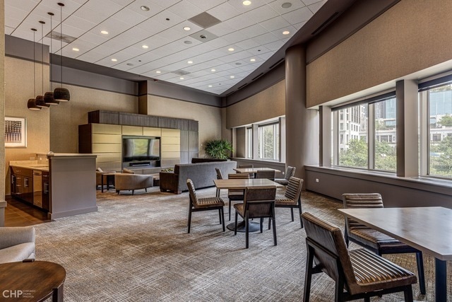 dining space featuring plenty of natural light, a towering ceiling, carpet floors, and recessed lighting