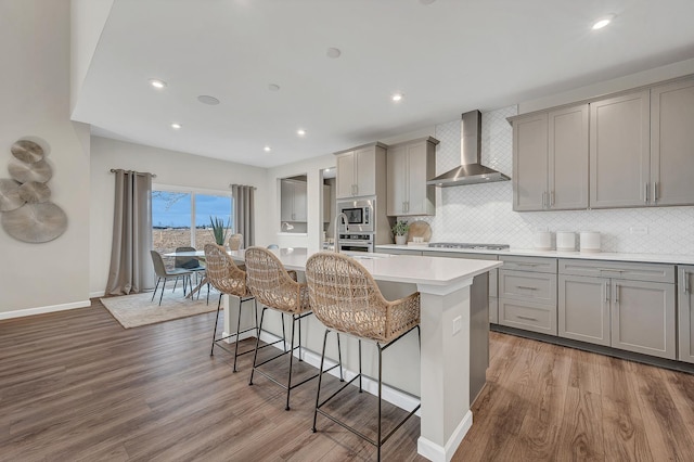 2547 Mallet Ct, Naperville, IL 60564 - kitchen with wall chimney exhaust hood, light wood finished floors, gray cabinetry, light countertops, and appliances with stainless steel finishes