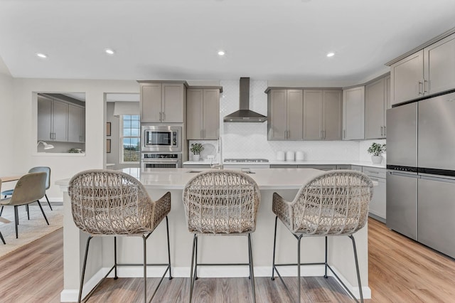 2547 Mallet Ct, Naperville, IL 60564 - kitchen featuring wall chimney exhaust hood, a sink, built in appliances, decorative backsplash, and gray cabinetry