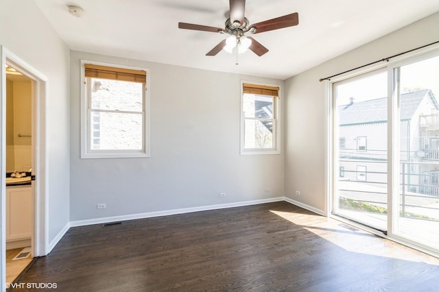 spare room with a smoke detector, dark wood-style flooring, a ceiling fan, and baseboards