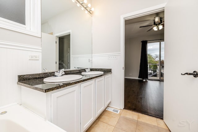 full bathroom with wainscoting, double vanity, tile patterned floors, and a ceiling fan