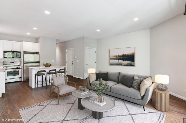 living room featuring dark wood finished floors, recessed lighting, and baseboards