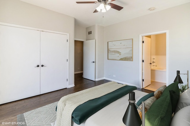 bedroom featuring wood finished floors, ensuite bathroom, a closet, and baseboards