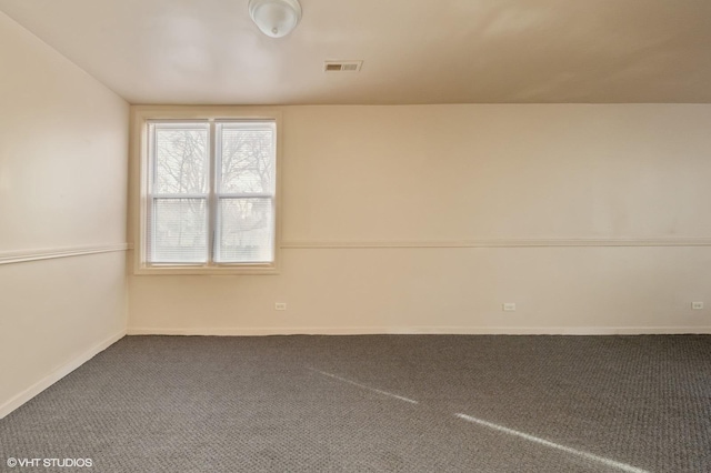 unfurnished room with baseboards, visible vents, and carpet