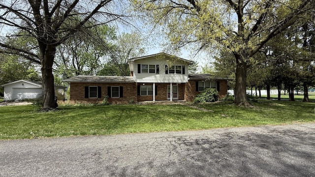 203 S Whitehead St, Tolono, IL 61880 - view of front facade featuring brick siding, a detached garage, and a front yard
