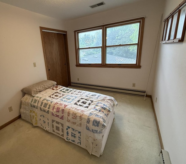 203 S Whitehead St, Tolono, IL 61880 - bedroom with baseboard heating, light carpet, and a closet