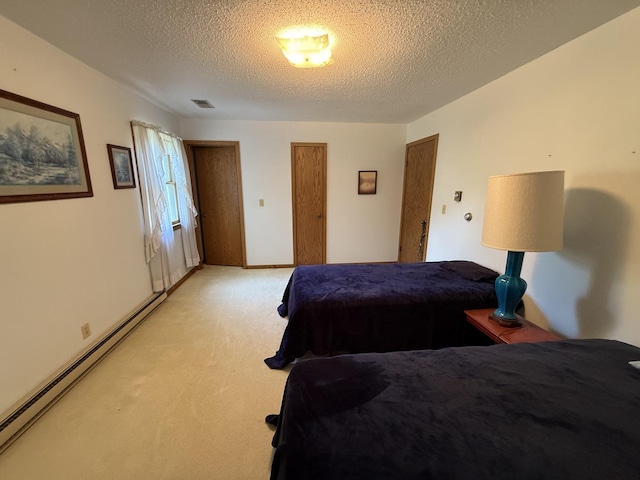 203 S Whitehead St, Tolono, IL 61880 - bedroom featuring baseboard heating, a textured ceiling, light colored carpet, and two closets