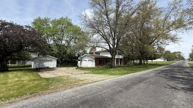 203 S Whitehead St, Tolono, IL 61880 - view of front facade with a garage, a front yard, and a chimney