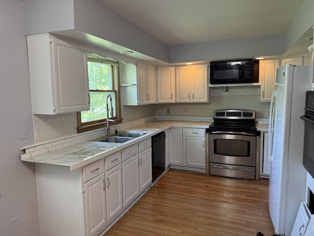 203 S Whitehead St, Tolono, IL 61880 - kitchen featuring black appliances, light countertops, dark wood finished floors, backsplash, and white cabinetry