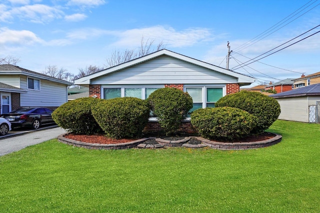 view of front of house featuring brick siding and a front lawn