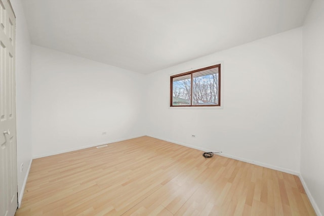unfurnished room with baseboards and light wood-style floors