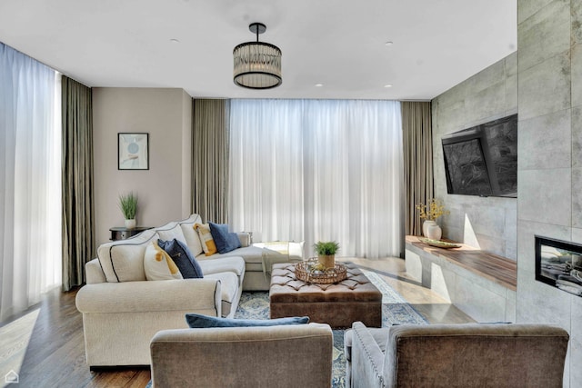 living room with a tile fireplace, wood finished floors, and expansive windows
