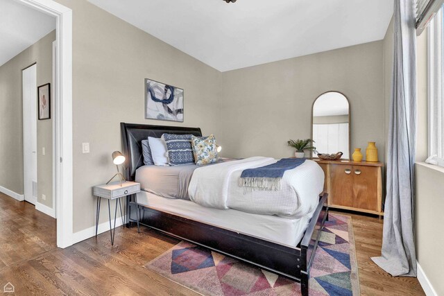 bedroom featuring wood finished floors and baseboards