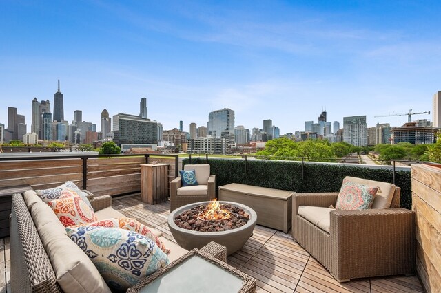 wooden terrace with an outdoor living space with a fire pit and a city view